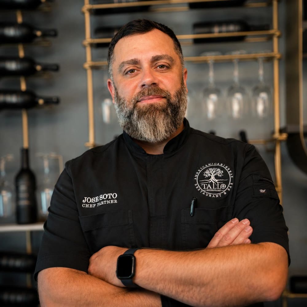 Chef Partner José Soto standing arms crossed at the Tallo bar in his black chef jacket