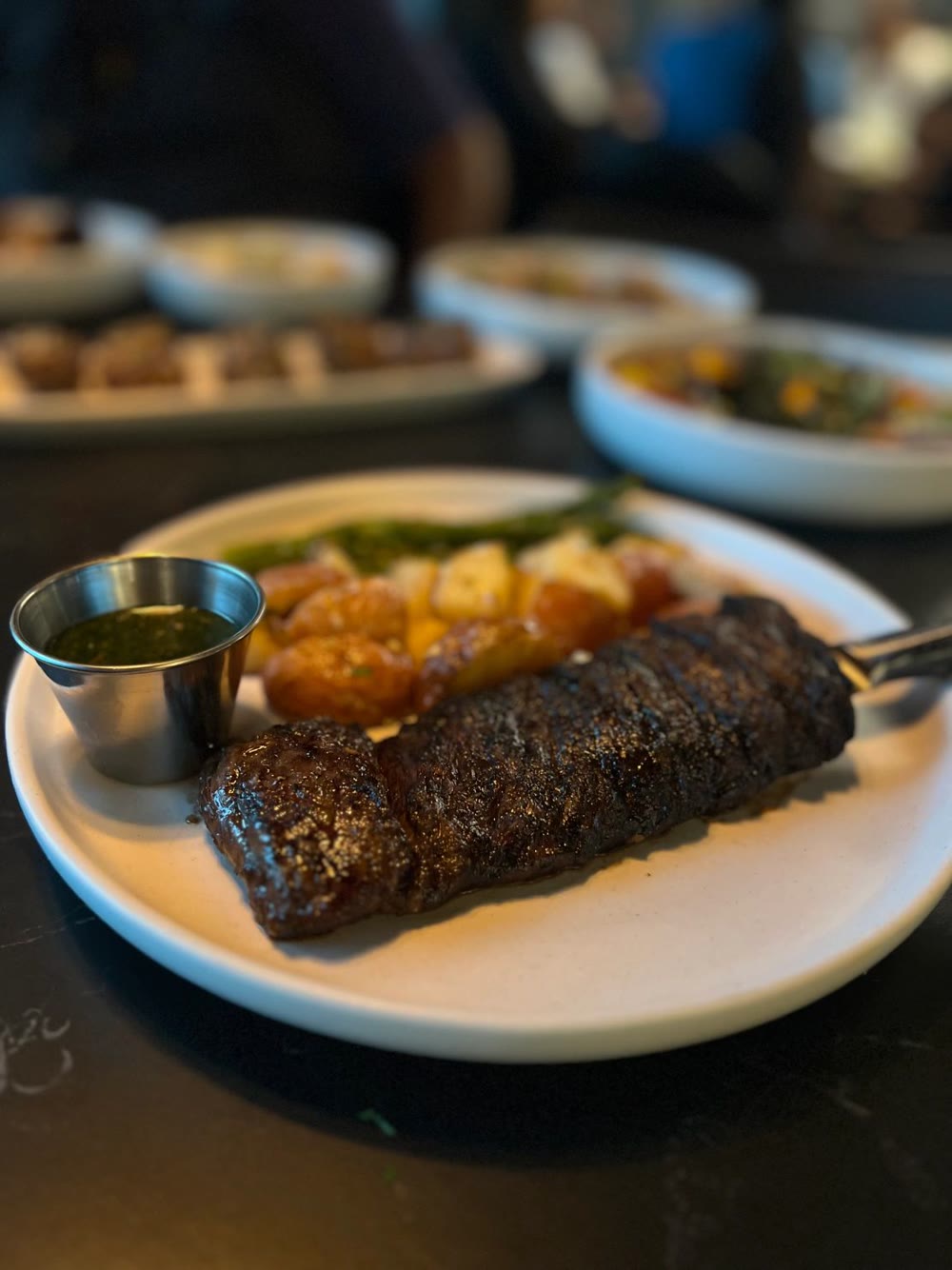 Churrasco with tostones and chimichurri on the black marble table at Tallo