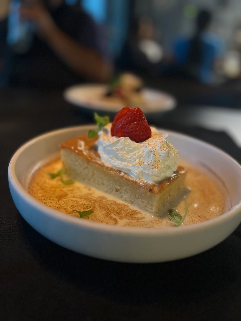 Tres leches sponge cake with whipped cream and a strawberry