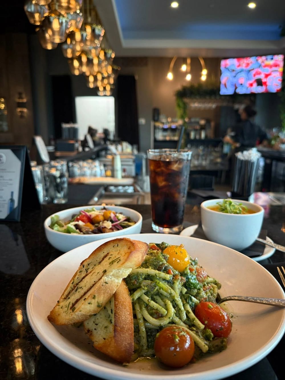 Pistachio pesto bucatini with shrimp and tomatoes, served with toasted bread